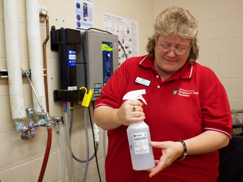 Jodi Krause shows a bottle of aqueous ozone cleaning solution