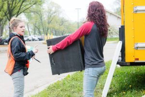Two students lift boxes of donated items