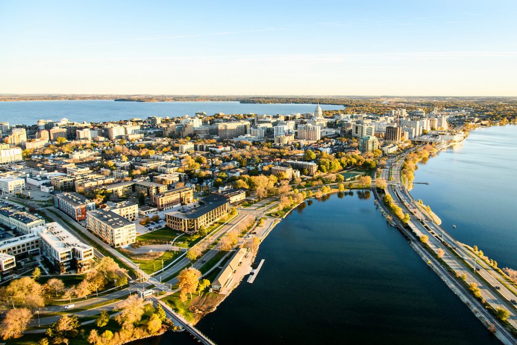 The downtown Madison Isthmus and the Wisconsin State Capitol, along with Monona Bay and John Nolen Drive, are pictured in an early morning aerial taken from a helicopter on Oct. 23, 2018. (Photo by Bryce Richter /UW-Madison)