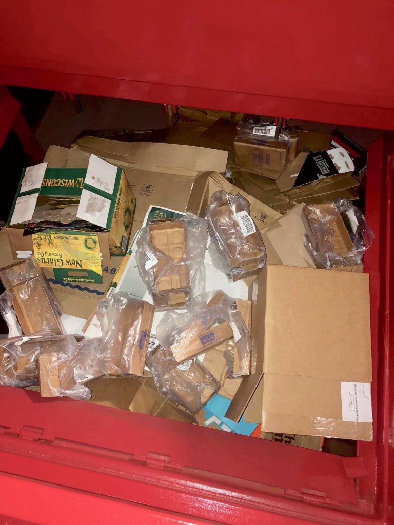 Cardboard waste showing contamination by plastic material. 