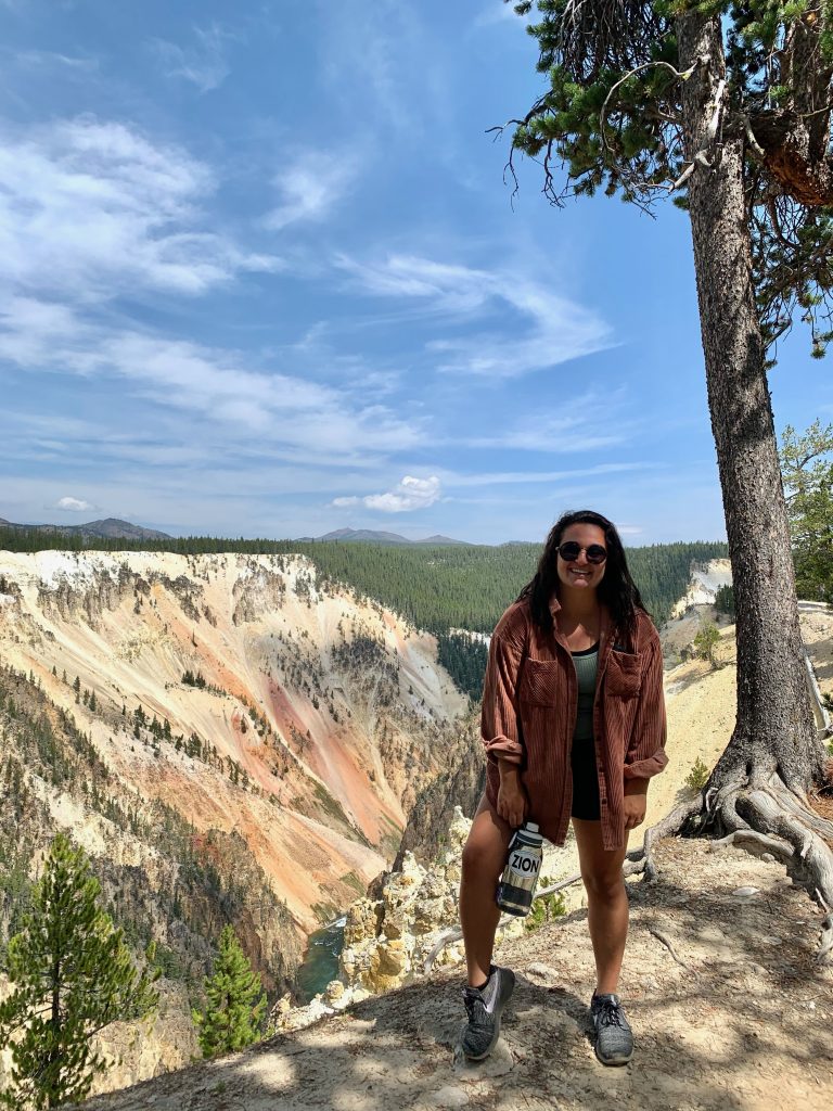Sanauz Alaei stands in front of a canyon with a blue sky above