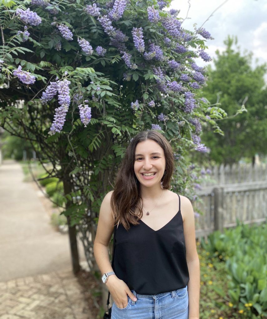 Photo of Carolyn Hamburg in front of a flowering tree. 