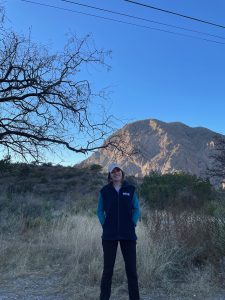 Carolyn Hamburg standing in front of a distant mountain and blue sky. 