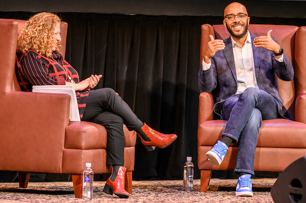 Go Big Read author Clint Smith gestures while talking to Chancellor Jennifer Mnookin in Shannon Hall at the Memorial Union Theater at the University of Wisconsin–Madison on Nov. 1, 2022. Go Big Read (GBR), a common-reading program, is designed to engage students, faculty, staff and the community in a shared, academically focused reading experience. (Photo by Althea Dotzour / UW–Madison)