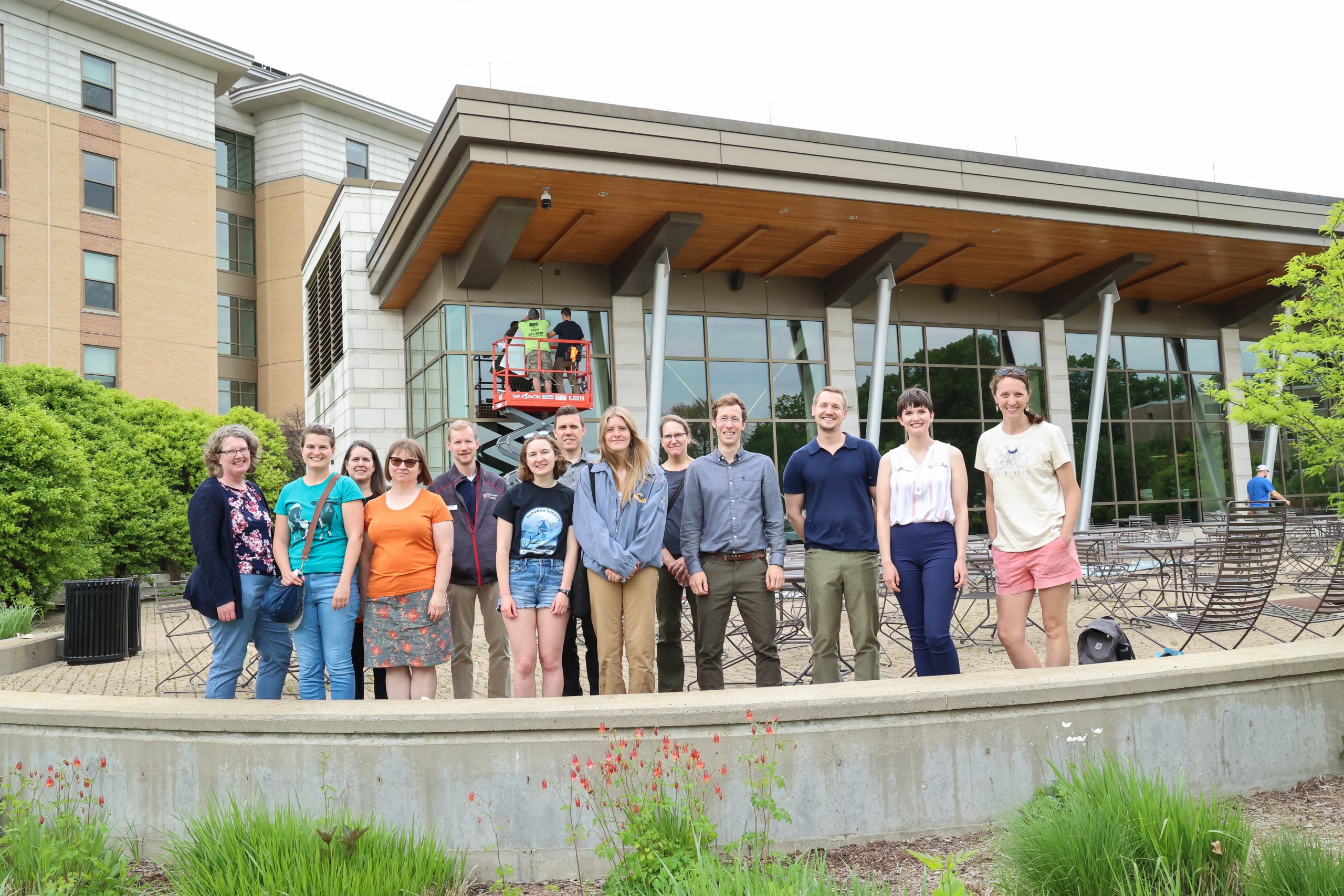 A group involved in the project gathers outside of Dejope Residence Hall to watch the installation of Bird-Friendly glass.
