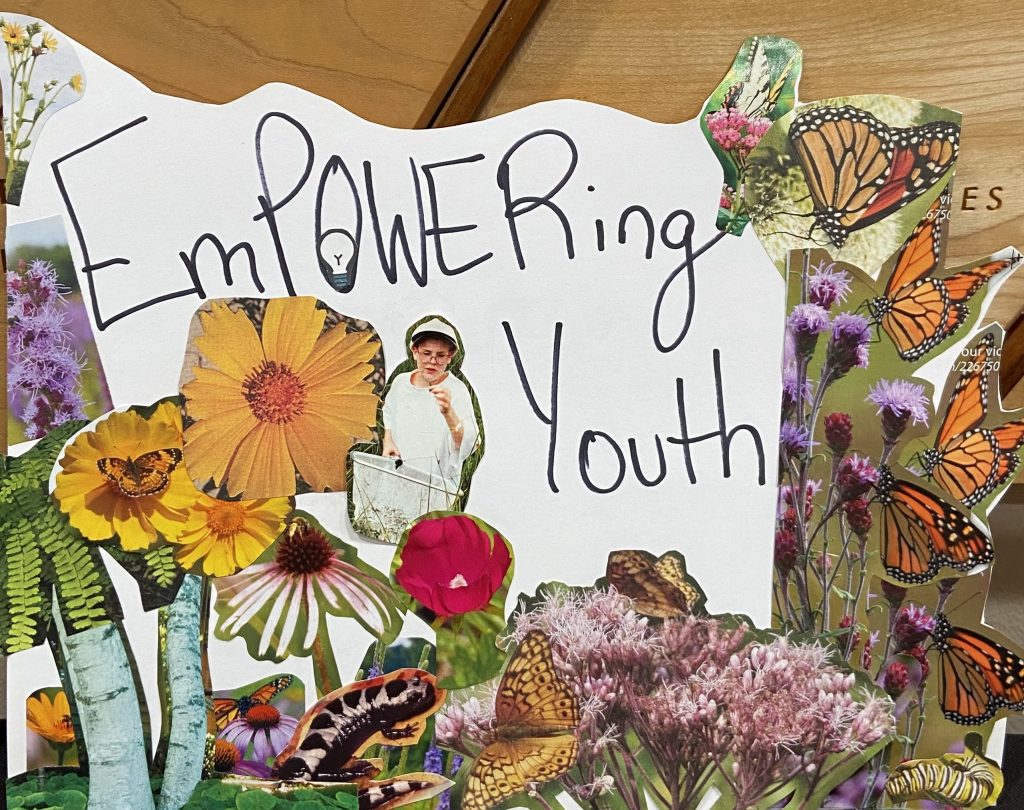 A poster reading "EmPOWERing Youth and featuring cut-out photos of flowers and a young person