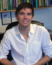 Sean Schoville sitting in a desk chair wearing a white shirt
