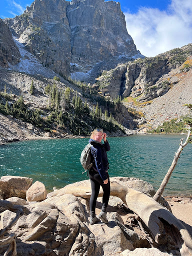 Mackenzie stands in front of a majestic view at Emerald Lake in Rocky Mountain National Park, Colorado.