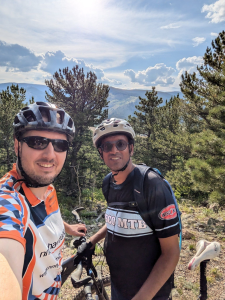 Ankur Desai with a friend standing with mountain bikes in the mountains