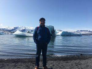 Feng He standing on a shoreline with icebergs in the background