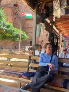 Anita Thompson lounging next to a cat in Jordan.