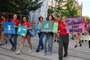 Students march with signs about sustainability down Library Mall