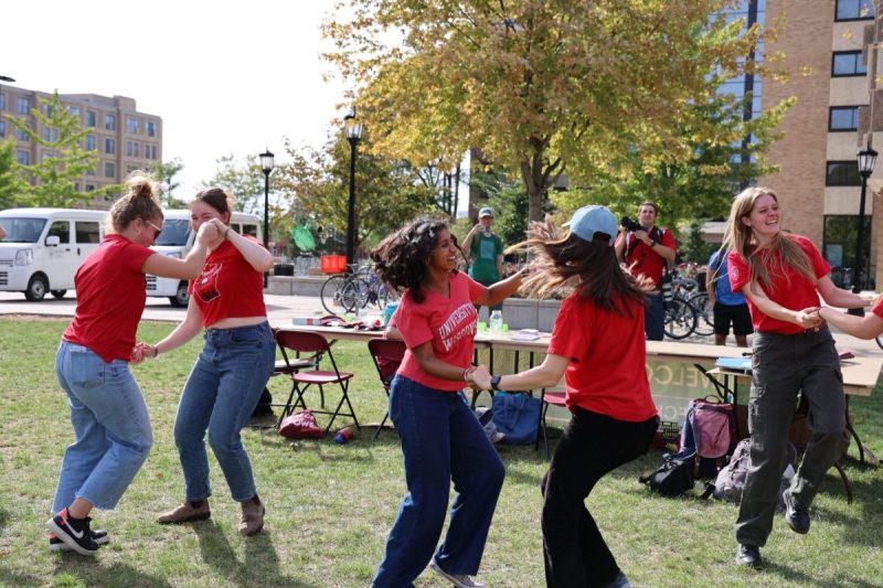 Student interns dance in pairs in the grass at the Sustain-a-Bash Showcase.