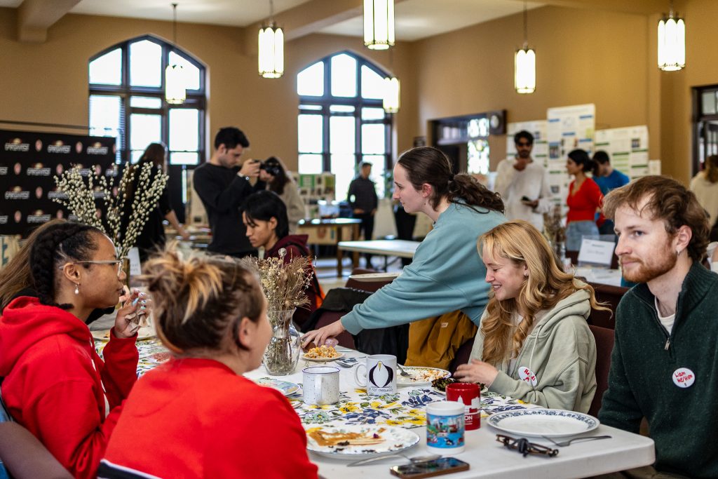 Students sit and eat around table at 2024 Spring Roundtable dinner.