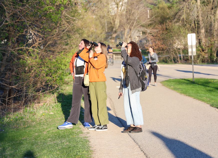 Students observing birds through binoculars off the Lakeshore Path.