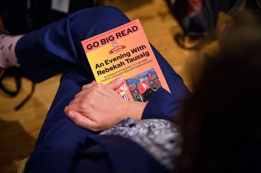 Audience member holds the program for “An Evening with Rebekah Taussig” during the Go Big Read keynote conversation in Varsity Hall. Photo by Althea Dotzour / UW–Madison