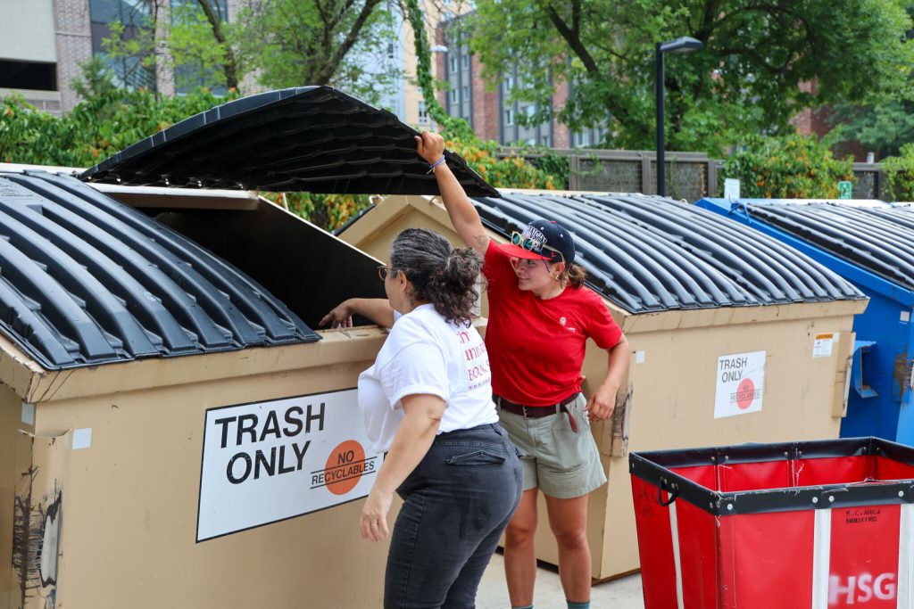 Student holds dumpster open for parent