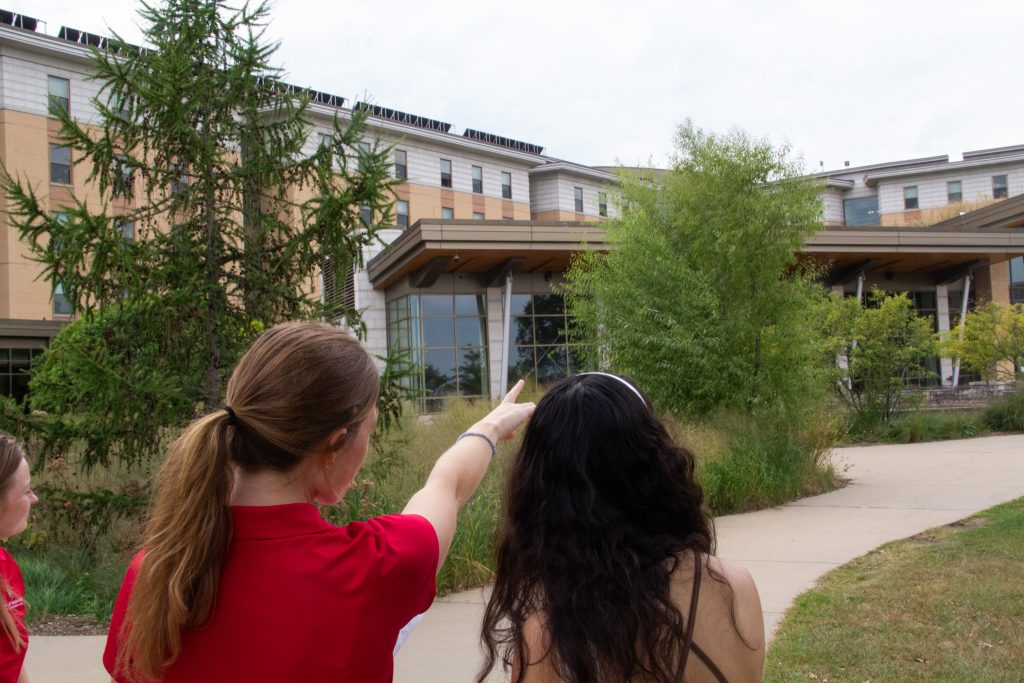 Intern pointing out sustainable features on Dejope Residence Hall.