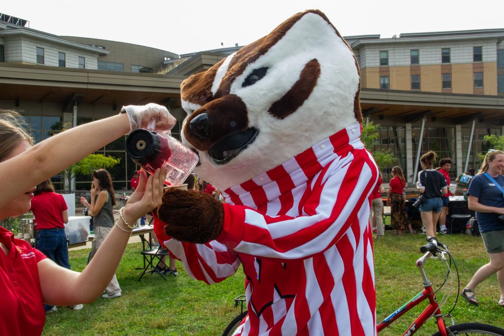 Student pouring Bucky a smoothie.