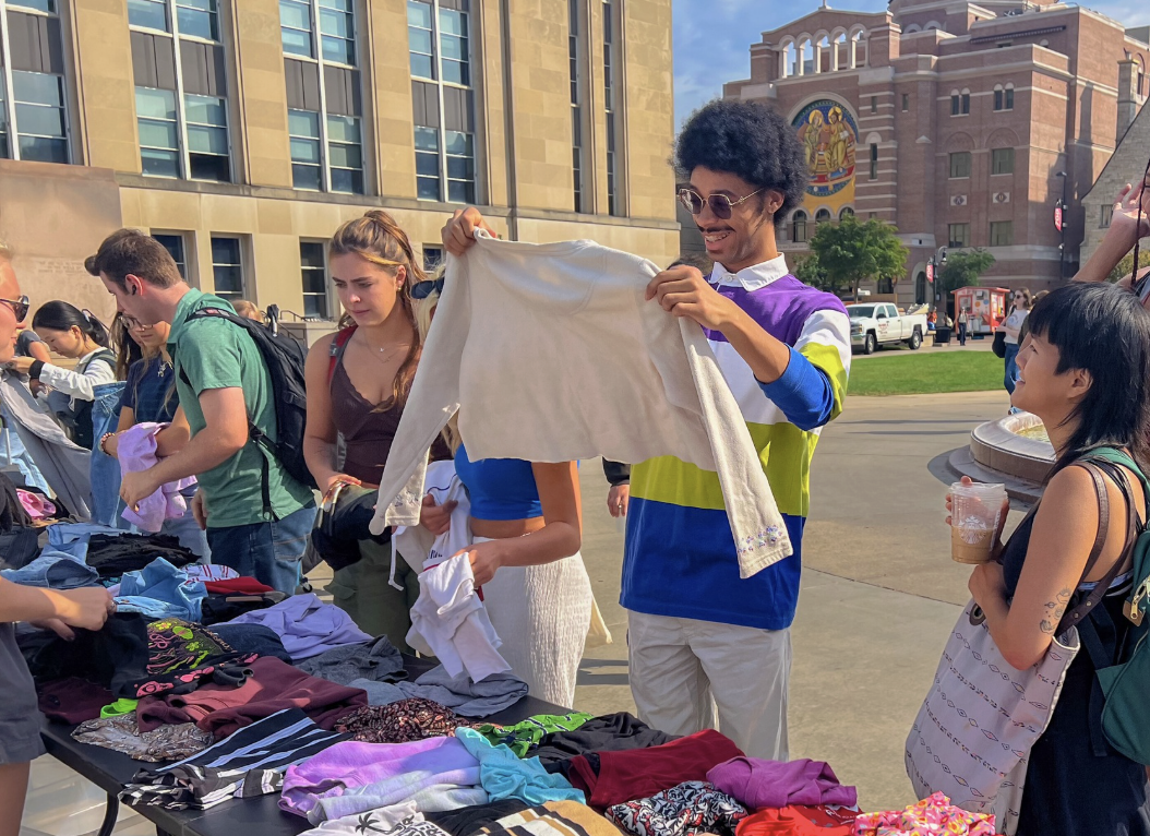 A number of students happily peruse clothing during a Re-Wear It clothing swap on Library Mall.